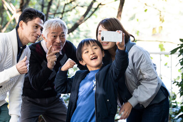みんなで仲良く家族写真を撮っている親子とおじいちゃん