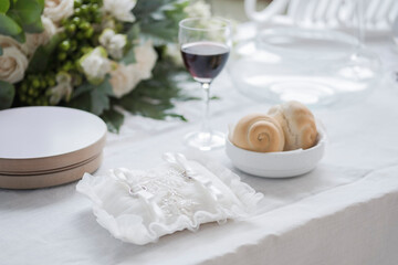 Wedding rings for Christian ceremony.  Wedding rings, wine and bread during a Christian ceremony.  Wedding bouquet. Table setting for a wedding.