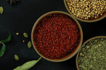 Wide variety spices and herbs on background of black table