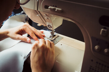 Young tailor sewing christmas decorations for children's party. Selective focus. Shallow depth of...