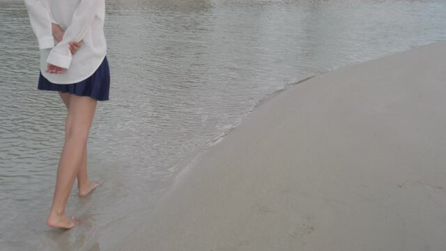 A woman walks alone on the beach. Lonely concept
