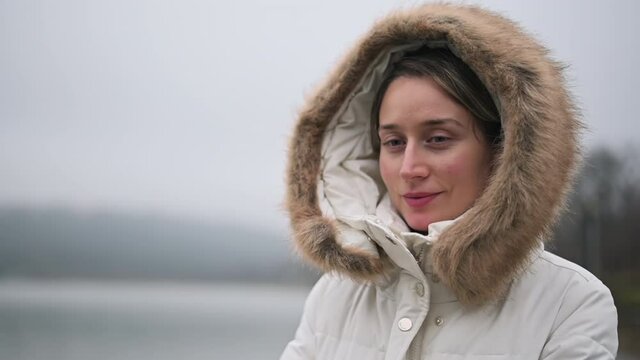 Woman in white winter coat smiling in the park