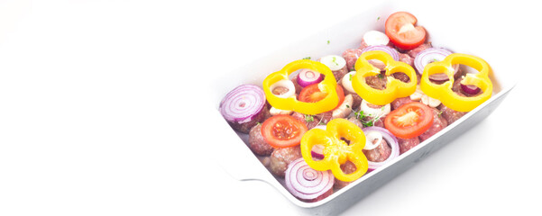 raw meat balls with vegetables and microgreens isolated on white