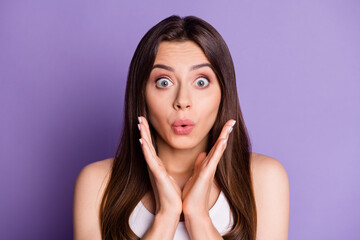 Photo portrait of surprised woman with hands near face isolated on vivid purple colored background