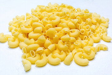 Uncooked raw Italian pipe rigate pasta on isolated white background.