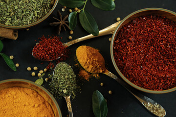 Wide variety spices and herbs on background of black table