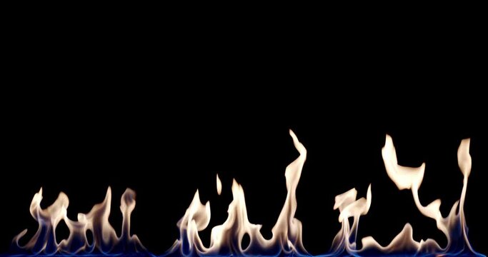 Fire flame Isolated on black background. Fire Flames Igniting And Burning Slow Motion. A line of real flames ignite on a black background Real fire. Perfect for the layer with different blending modes