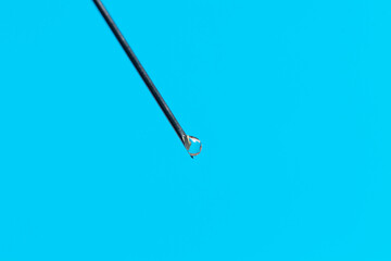 Macro photo of a medical needle from a syringe on a blue background. The concept of vaccination in health care