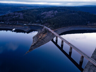 Aerial landscape view of bridge over reservoir, Harz mountains in Lower Saxony, Germany. Calm and dark blue water of the Okertalsperre, Oker Dam.