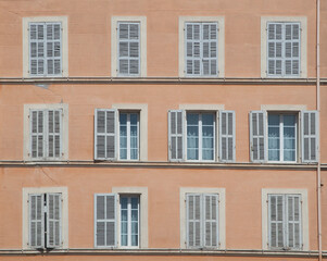 Fototapeta premium typical facade of an old hotel with open and closed shutters in traditional style