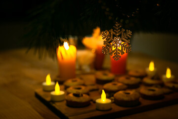 New year atmosphere at home. Very nice pine tree at home. Illuminated room.Decoration for New Year. December day. Deer, Christmas tree, beads.  Snowflakes, deer, candles.