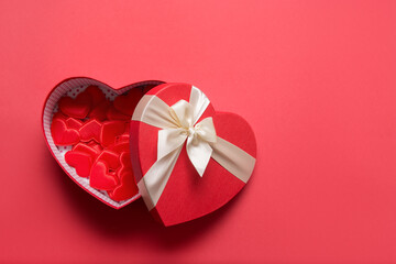 Valentine's Day hearts gift on red background. Romance greeting card with copy space. View from above.