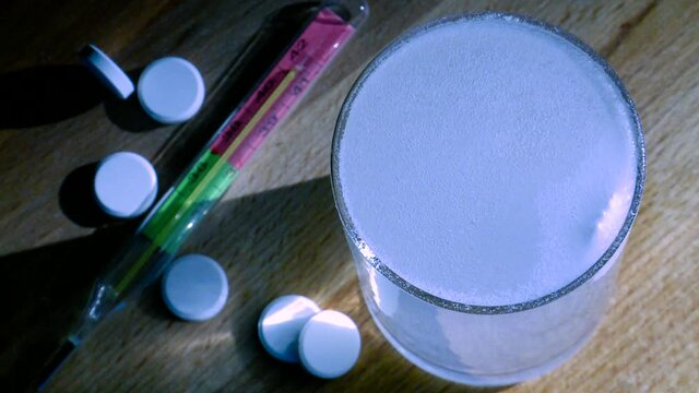 The medicine tablet is dissolved in a glass of water.