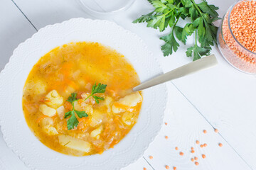 Delicious homemade red lentil soup in a white plate. Healthy vegan food.