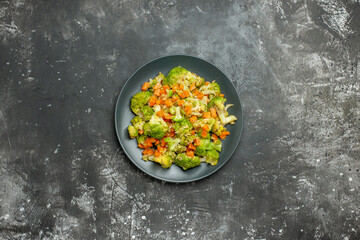 Healthy meal with brocoli and carrots on a black plate on gray background stock image