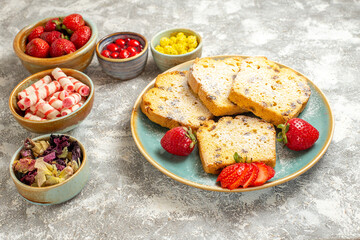 front view yummy cake slices with candies and fruits on light background cake sweet pie