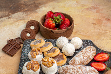 front view different sweets with cookies and fruits on light desk fruits sugar pie cake