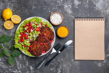 top view tasty meat cutlets with salad and seasonings on grey floor photo food dish