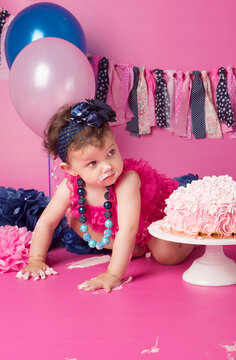 Cumplea&ntilde;os ni&ntilde;a con pastel grande y decorado con globos, pompones y guirnalda