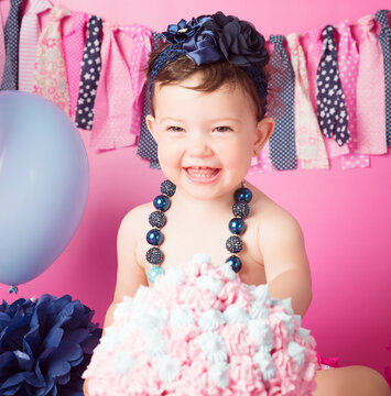 Cumplea&ntilde;os ni&ntilde;a con pastel grande y decorado con globos, pompones y guirnalda