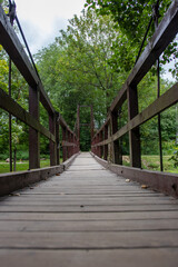 Fototapeta na wymiar old wooden suspension bridge. bridge over the forest river