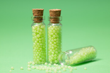 glass bottles with corks with green granules on a green background