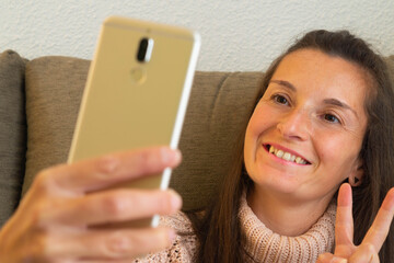 Face of a smiling woman who is taking a selfie photo with the mobile