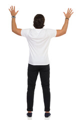 Rear View Of Man Standing With Hands Raised.