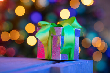 a perfect little christmas gifts onder a christmastree with lights in the background - Christmas presents under a tree