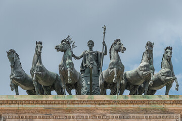 Obraz premium Statues of 6 horses and Goddess Victoria at the top of Triumphal Arch called Arch of Peace (Porta Sempione) in Milan historical downtown, Sempione Park, Italy.