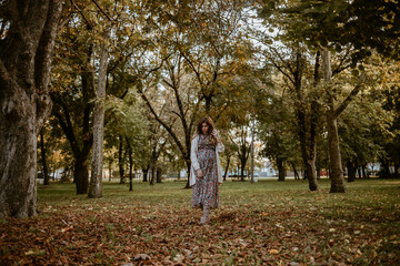 Beautiful pregnant woman walking in the park