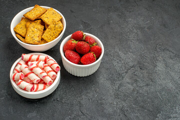 front view different eatings crisps fruits and candies on dark background tea sweet photo cracker