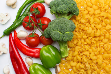 Raw pasta and vegetables broccoli, tomatoes, peppers, garlic and mushroom