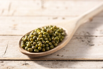 Green soy beans in wooden spoon on wooden table