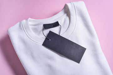 Black label of sweatshirt on pink background