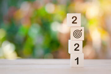 Wooden cube with New Year 2021 and goal target on top, changing year from 2020 to 2021.