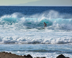 Surfista cogiendo olas con una bonita puesta de sol