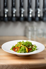 Roasted yellow and red bell pepper salad with capers and olives in a blue bowl.