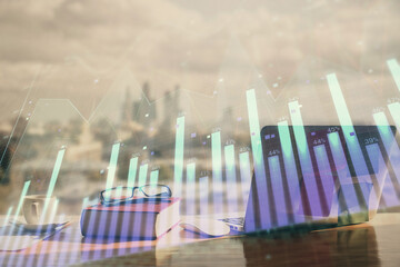 Double exposure of financial chart drawings and desk with open notebook background. Concept of forex market