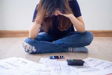 Young women sitting is hand-to-head are worried about credit card liabilities and monthly bills....