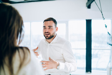 Young man talking to friend at Christmas party