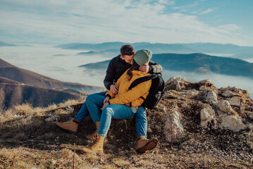 happy couple man and woman tourist at top of mountain during a hike in summer