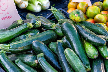 A group of green courgettes at a street market in the city.
