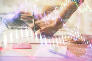 Multi exposure of woman hands typing on computer and financial chart hologram drawing. Stock market...