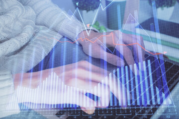 Double exposure of woman hands typing on computer and forex chart hologram drawing. Stock market...
