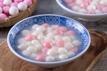 Close up of red and white tangyuan in blue bowl on wooden background for Winter solstice.