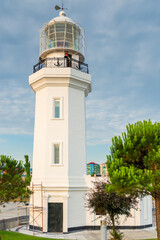 white lighthouse on the city shore, photograph on a clear day