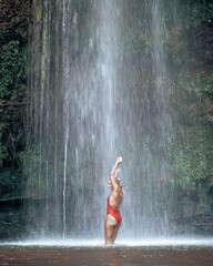 Woman in bikini at tropical waterfall in Lombok Indonesia
