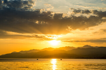 View of the sea and mountains during sunset. photography in orange and yellow tones