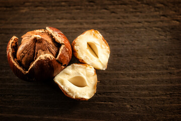 Top view of cracked hazelnuts on dark wooden background